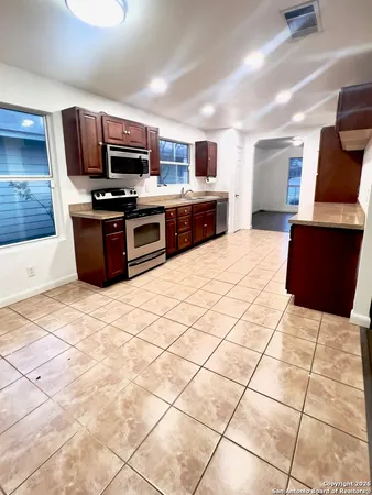 a kitchen with stainless steel appliances kitchen island granite countertop a stove top oven a sink a counter top space and cabinets