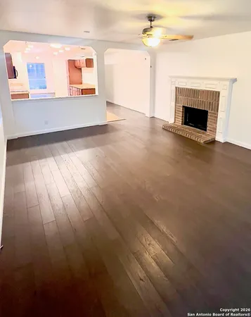 an empty room with windows and fireplace