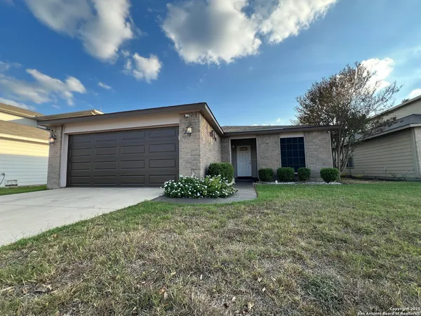 a front view of house with yard and garage