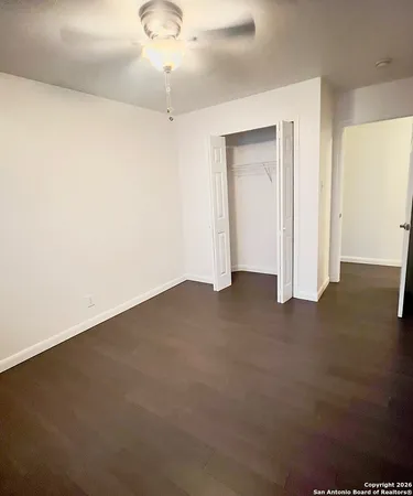 an empty room with a ceiling fan and a window
