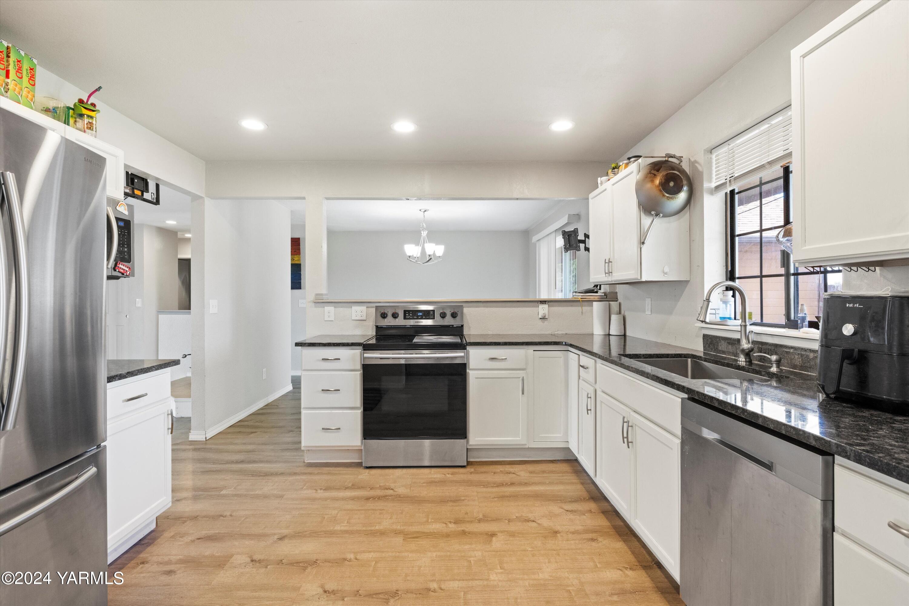 341 Jones Road Wapato, WA 98951 - Photo 5 of 18 a large kitchen with stainless steel appliances granite countertop a refrigerator and a sink