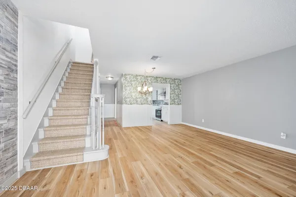 a view of a room with wooden floor and staircase