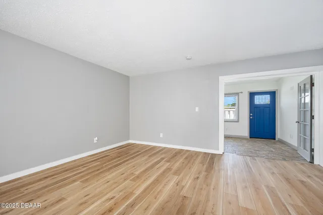 a view of an empty room with wooden floor & closet