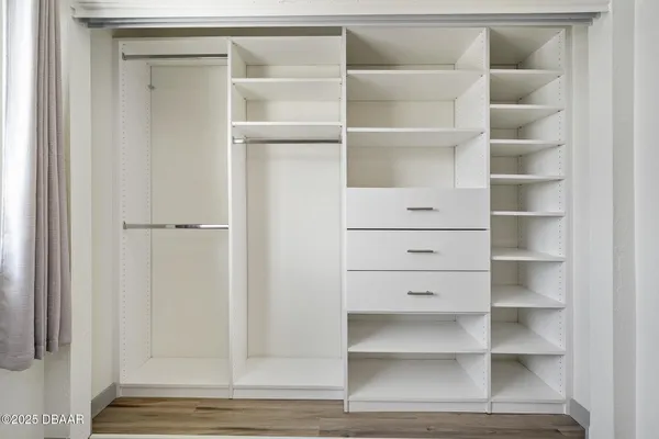 a view of walk in closet with empty racks