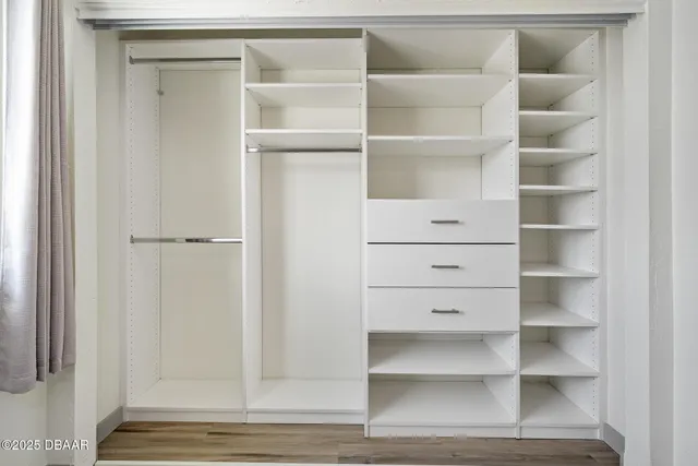 a view of walk in closet with empty racks