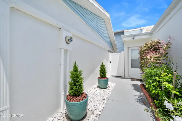 a front view of a house with potted plants