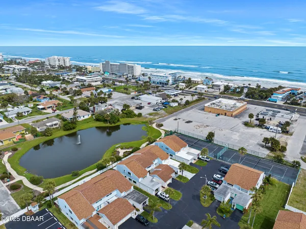 an aerial view of a city with lots of residential buildings and ocean view in back