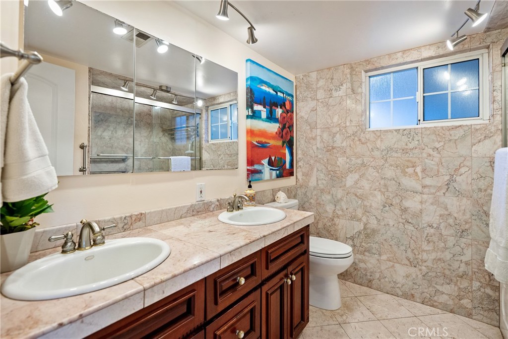 1002 Par Avenue Paso Robles, CA 93446 - Photo 22 of 59 a bathroom with a double vanity sink toilet and mirror