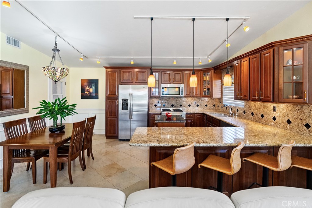 1002 Par Avenue Paso Robles, CA 93446 - Photo 7 of 59 a kitchen with a dining table chairs stainless steel appliances and cabinets