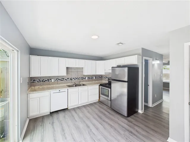 a kitchen with stainless steel appliances a refrigerator sink and stove