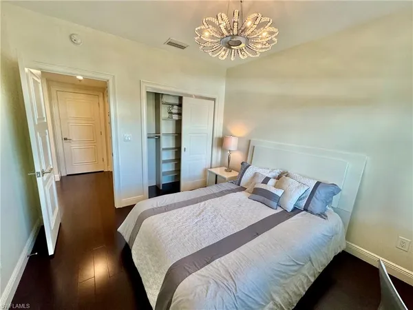 a bedroom with a bed and a chandelier