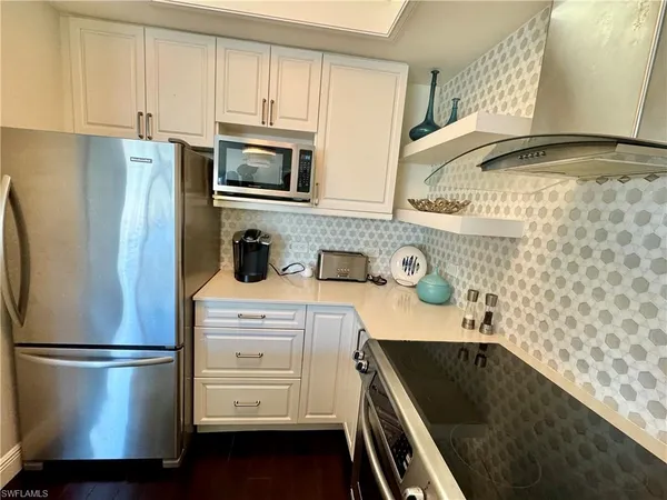 a kitchen with stainless steel appliances a refrigerator a sink and cabinets