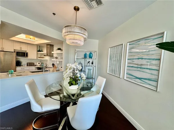 a view of a dining room with furniture a chandelier and wooden floor