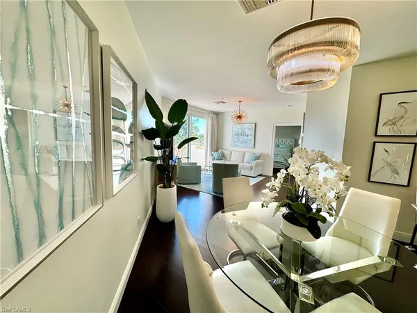 a living room with furniture chandelier and a large window