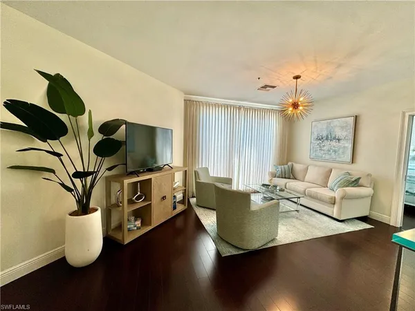 a living room with furniture wooden floor and a flat screen tv