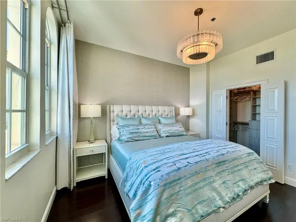 a bedroom with a bed and a chandelier