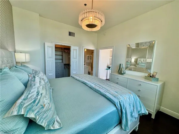 a spacious bedroom with a bed and a mirror