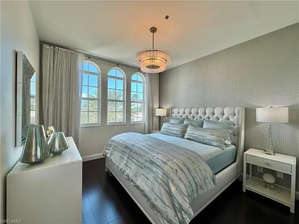 a bedroom with a bed and a chandelier
