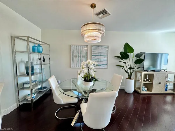 a view of a dining room with furniture wooden floor and chandelier