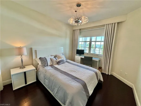 a bedroom with a bed and a chandelier