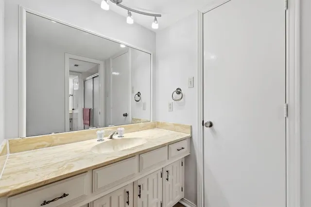 a bathroom with a granite countertop sink and a mirror