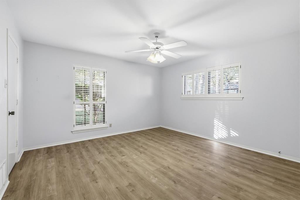 2505 Oak Manor Court Arlington, TX 76012 - Photo 15 of 23 an empty room with wooden floor chandelier fan and windows