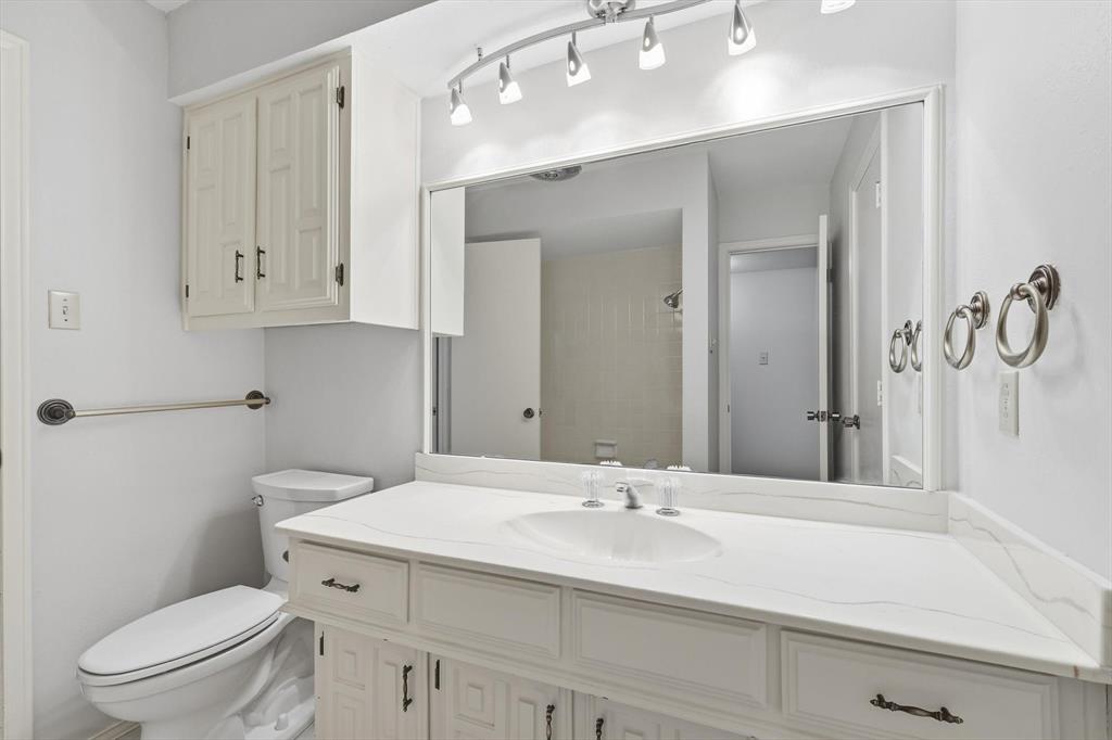 2505 Oak Manor Court Arlington, TX 76012 - Photo 18 of 23 a bathroom with a sink a toilet and a mirror