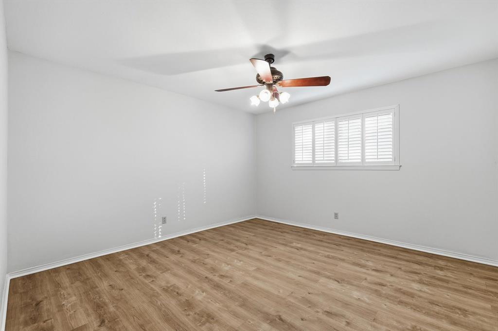 2505 Oak Manor Court Arlington, TX 76012 - Photo 19 of 23 an empty room with wooden floor fan and windows
