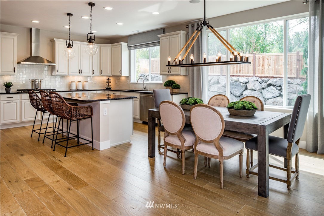 105 215th Street Southeast, Unit 4 Bothell, WA 98021 - Photo 6 of 15 a kitchen with granite countertop a table chairs stove a sink and cabinets
