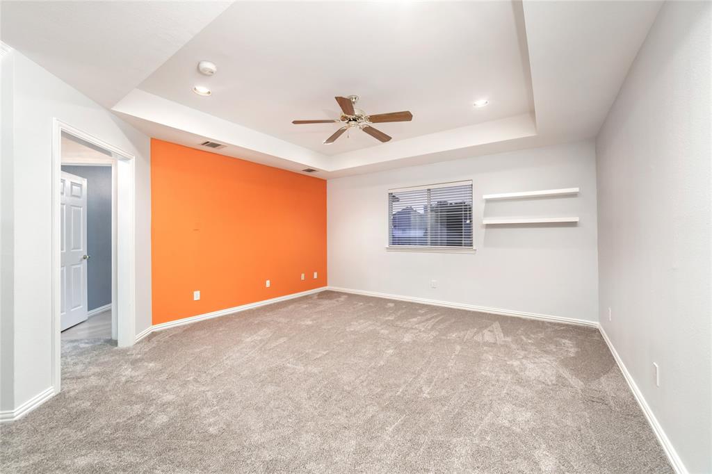 5801 Yeary Road Plano, TX 75093 - Photo 22 of 33 Spacious interior room featuring a tray ceiling with a ceiling fan, recessed lighting, and a vibrant accent wall