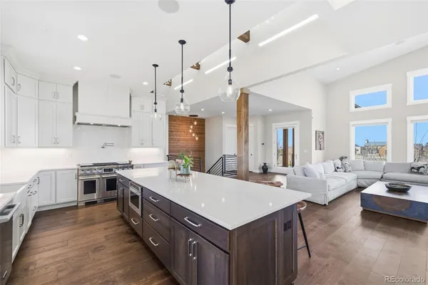 a large kitchen with kitchen island a stove a sink a center island and couches