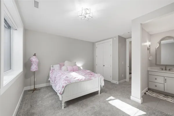 a spacious bedroom with a bed and a bathroom with mirror