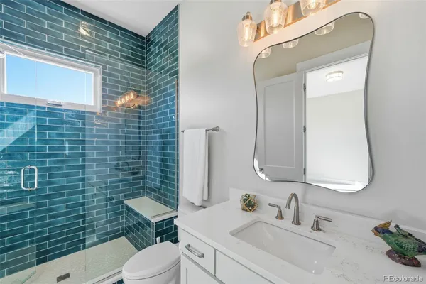 a bathroom with a toilet sink vanity and mirror