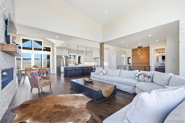 a living room with furniture kitchen view and a large window