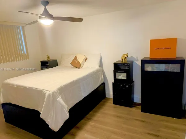 a bedroom with a bed and a ceiling fan