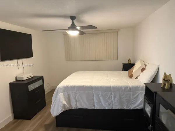 a bedroom with a bed and a flat screen tv
