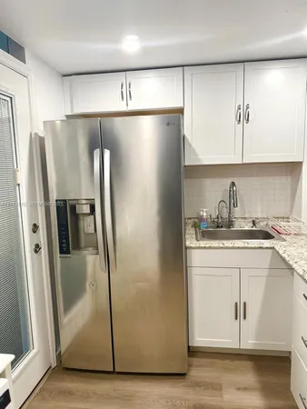 a kitchen with stainless steel appliances granite countertop a refrigerator and a sink
