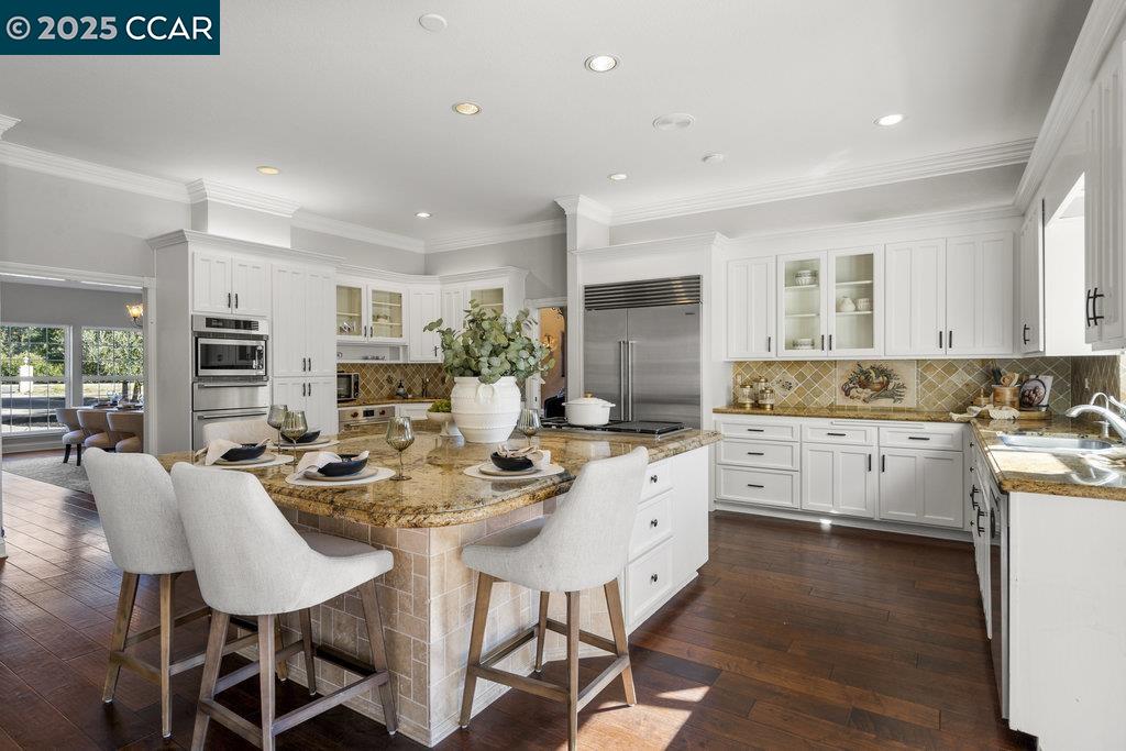5655 Bruce Drive Livermore, CA 94551 - Photo 12 of 47 a kitchen with stainless steel appliances kitchen island granite countertop a stove a sink a dining table and chairs