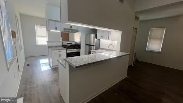a kitchen with counter top space and wooden floor