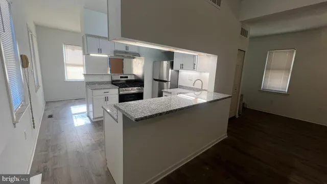 a kitchen with counter top space and wooden floor