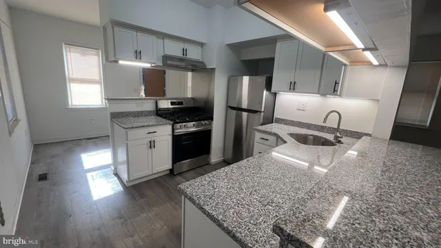 a kitchen with stainless steel appliances granite countertop a sink stove and refrigerator