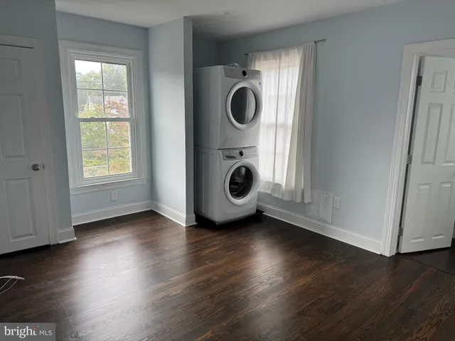 an empty room with wooden floor and window