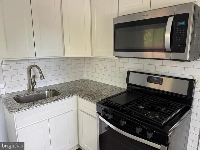 a kitchen with stainless steel appliances granite countertop a sink stove and microwave