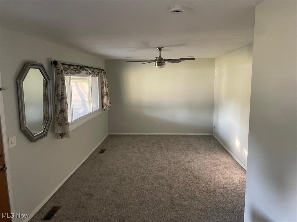 5741 Jaycox Road North Ridgeville, OH 44039 - Photo 9 of 23 Empty room with carpet flooring, a ceiling fan, and a smoke detector