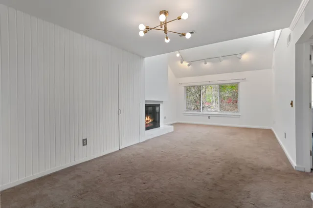 an empty room with windows and fireplace