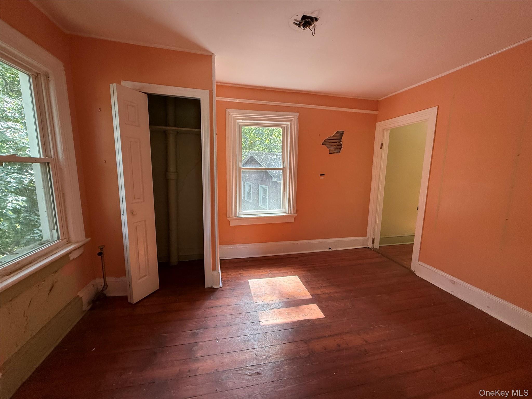 3968 Old Crompond Road Cortlandt Manor, NY 10567 - Photo 10 of 17 Unfurnished bedroom featuring dark wood-style flooring, a closet, and crown molding