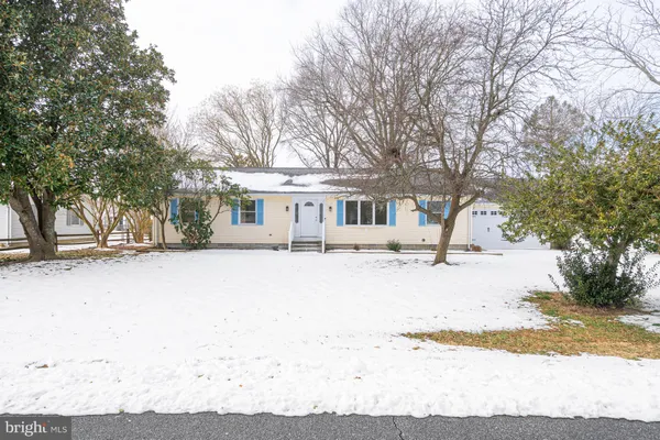 a front view of a house with a yard covered in snow