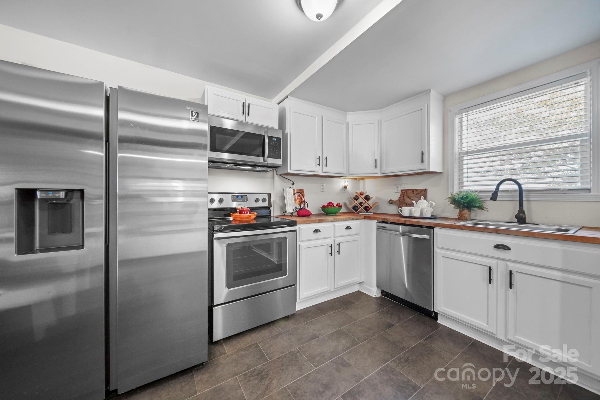 452 18th Street Cramerton, NC 28032 - Photo 11 of 35 a kitchen with stainless steel appliances granite countertop a refrigerator sink and stove