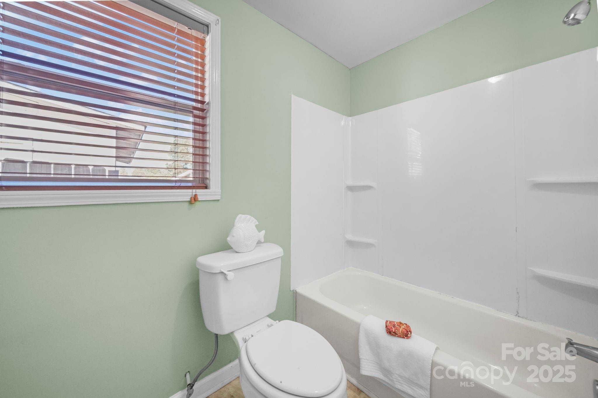 452 18th Street Cramerton, NC 28032 - Photo 22 of 35 a white toilet sitting next to a bathroom sink and tub