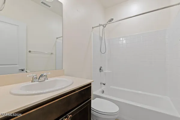 a bathroom with a granite countertop sink a toilet and shower
